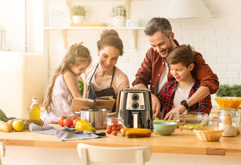 A happy family enjoying a meal prepared with an air fryer in a cozy Christmas-themed kitchen