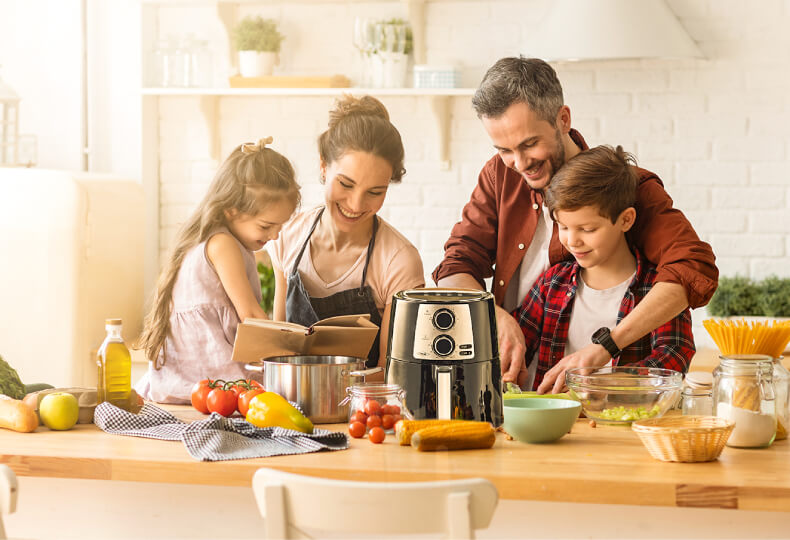 A happy family enjoying a meal prepared with an air fryer in a cozy Christmas-themed kitchen